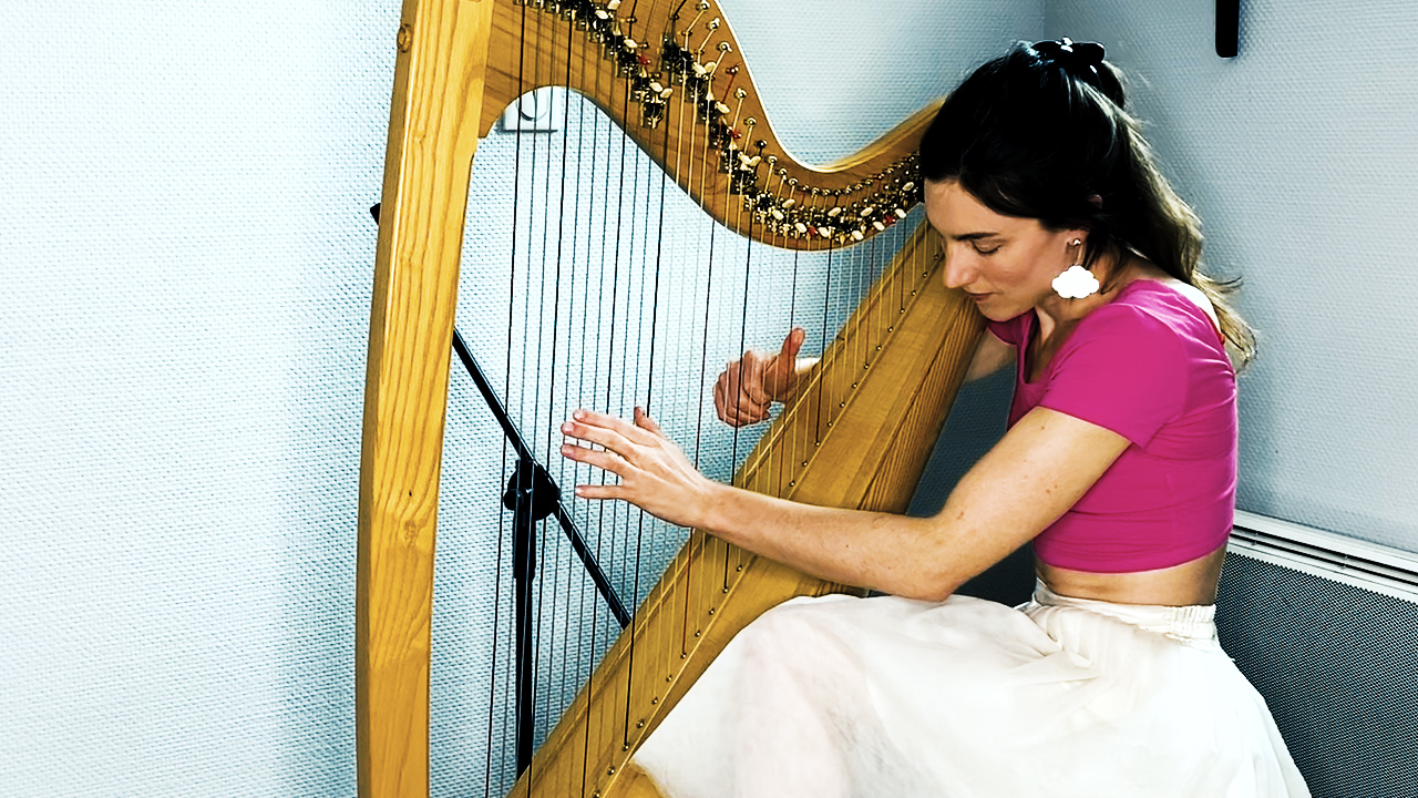 Portrait of Tamsin Dearnley playing her harp